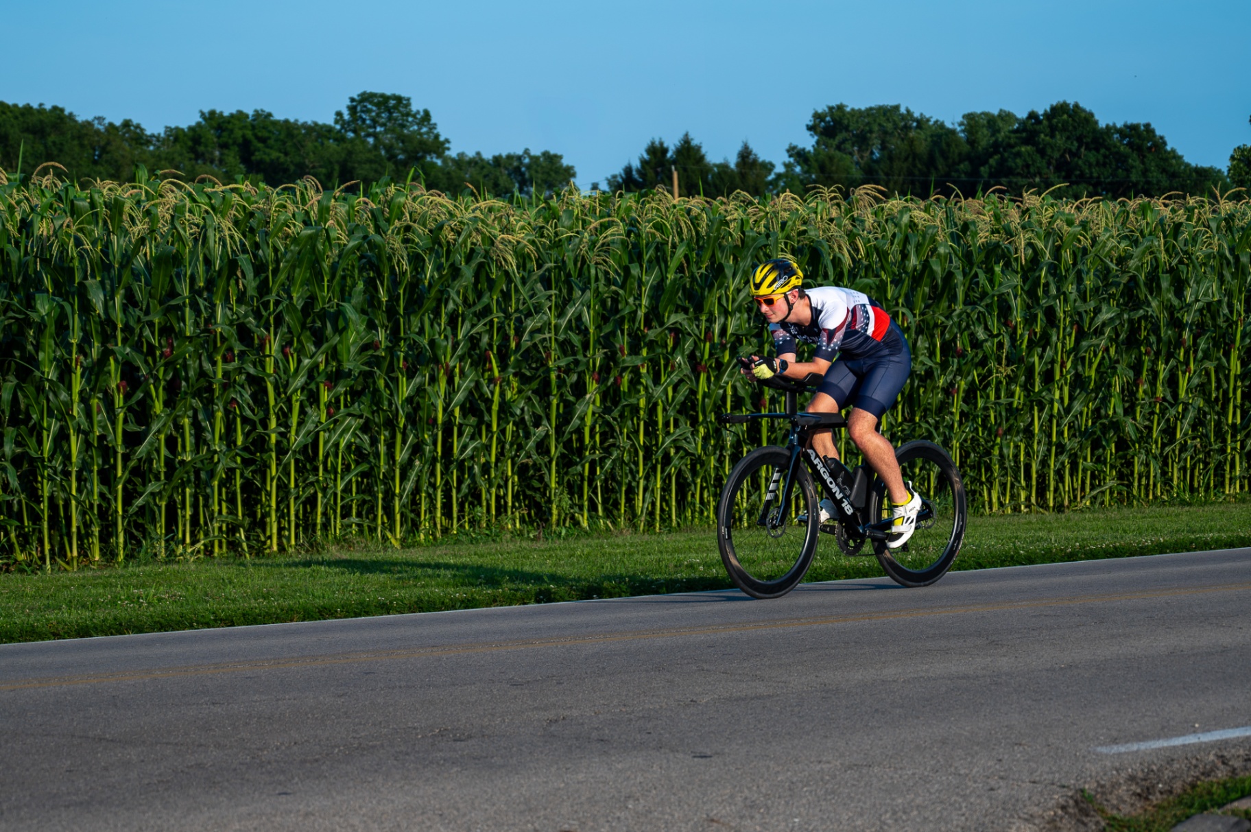 Xander Mac cycling past Indiana cornfields
